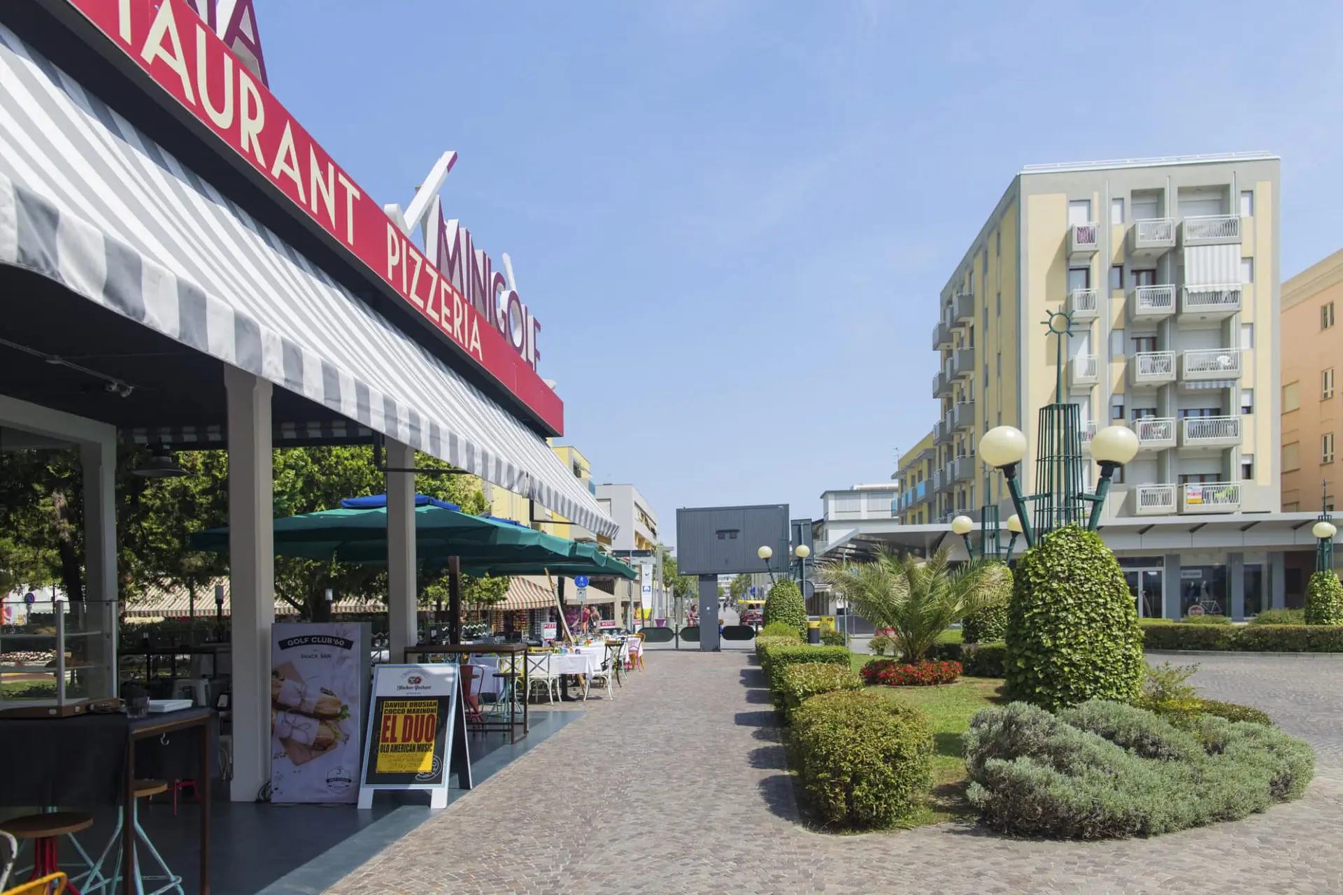 Pizzeria all'aperto in strada cittadina soleggiata