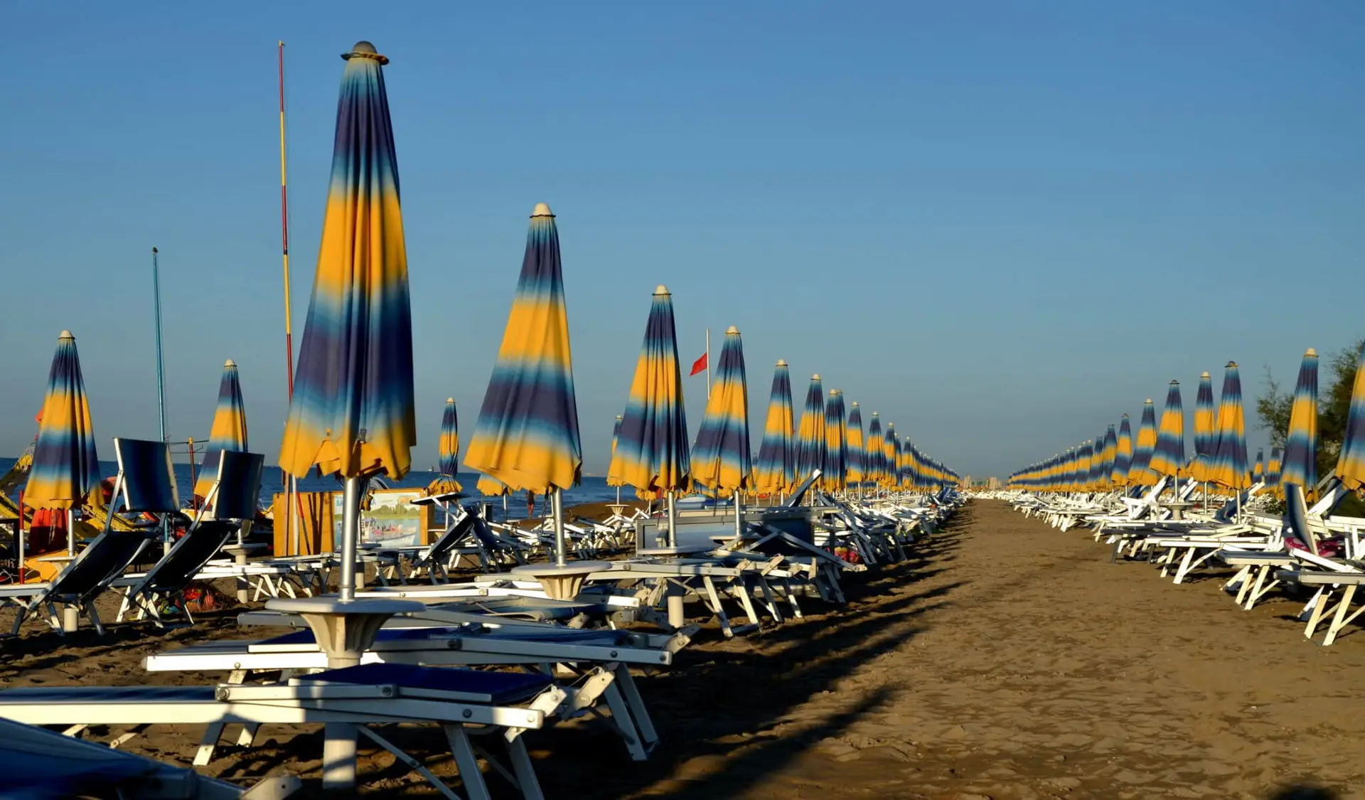 Ombrelloni colorati su spiaggia deserta al tramonto