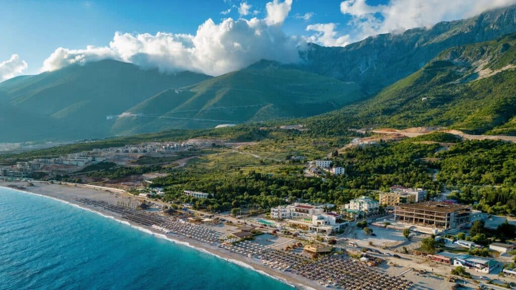 Veduta aerea di litorale con montagne e spiaggia affollata